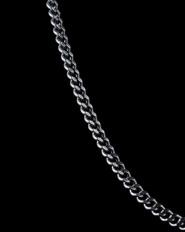 Cadena de plata de eslabones sobre fondo oscuro