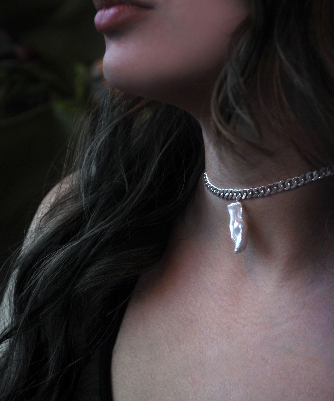 Detalle de un colgante de plata de ley sobre la piel